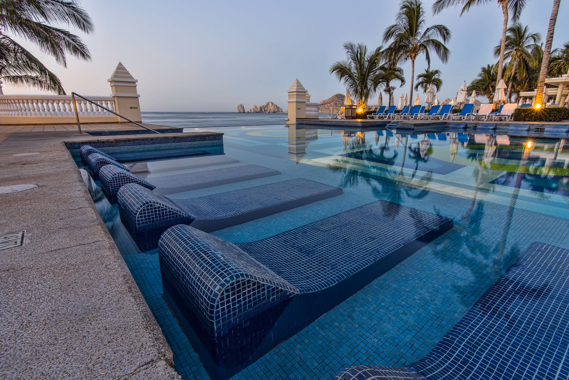 Blue sun loungers beside a resort pool, Rancho San Lucas amenities, Cabo San Lucas