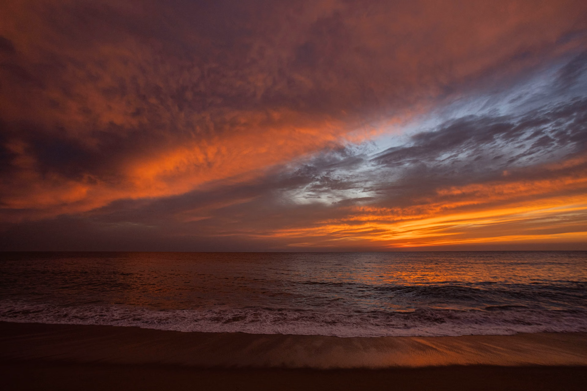 Dramatic sunset over a calm Pacific Ocean with colorful clouds